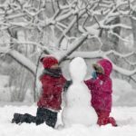 Children build  a snowman in a park in Bucharest, Romania, Monday, Dec. 29, 2014. Romania, especially the eastern part,  is affected by heavy snow falls and blizzards this year  that cause traffic disruptions but are enjoyed by children and mountain tourists. (AP Photo/Vadim Ghirda)